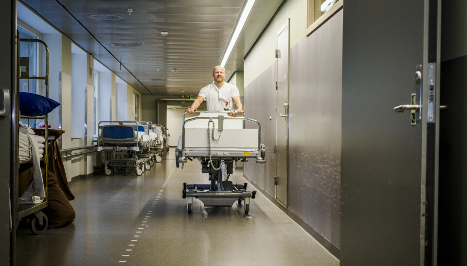Øyvind Orre skyver en sykehusseng gjennom en døråpning