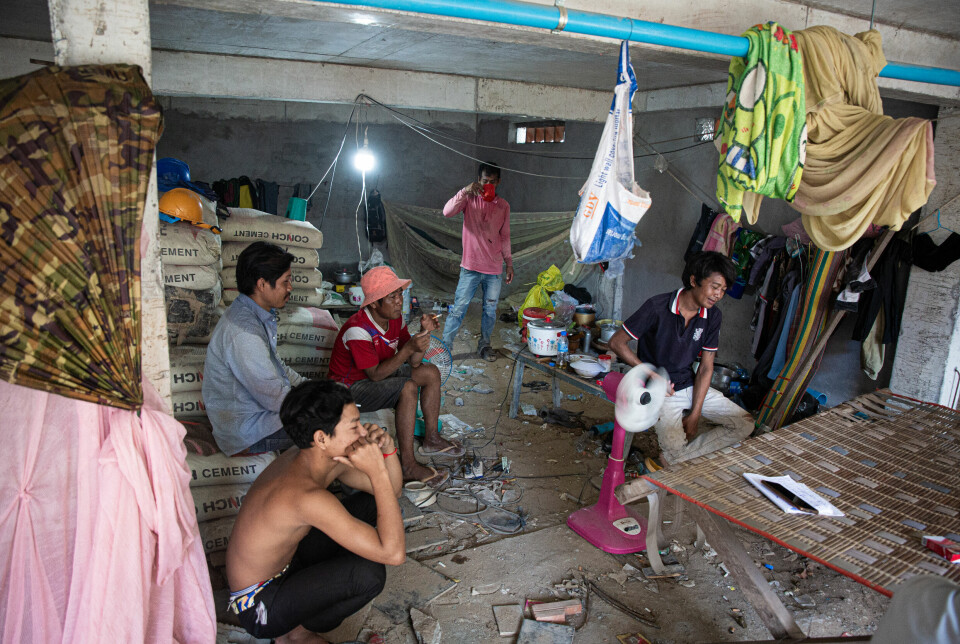 Bygningsarbeiderne har pause i rommet under bygget hvor de bor og arbeider.