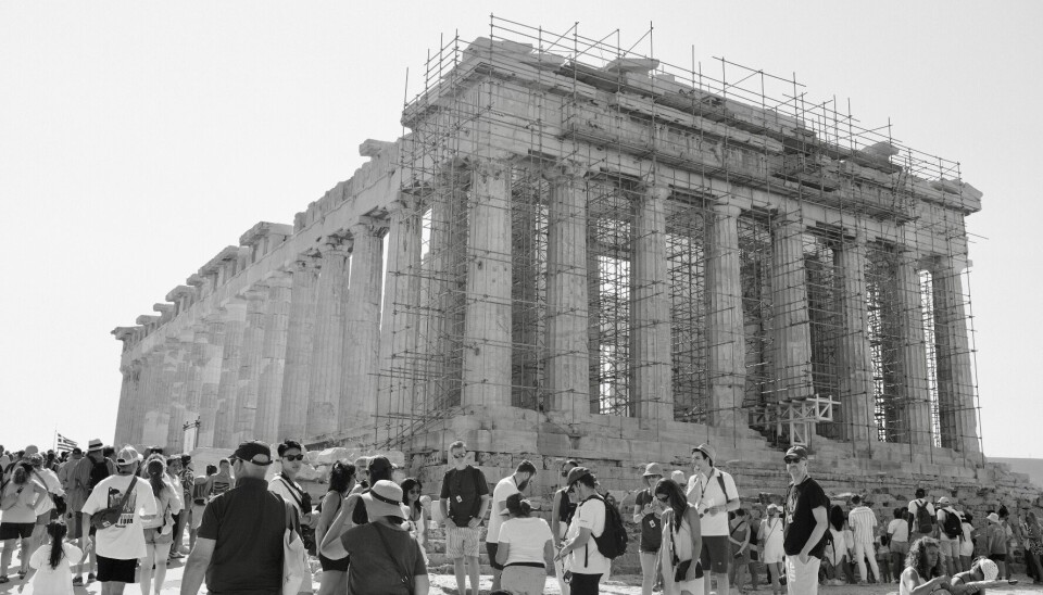 FARLIG HETT: Byggstillas på Akropolis under en hetebølge i fjor sommer. Greske arbeidstakere ønsker bedre beskyttelse mot arbeid i farlige temperaturer. Bilde fra Akropolis. Varme turister i forgrunnen.