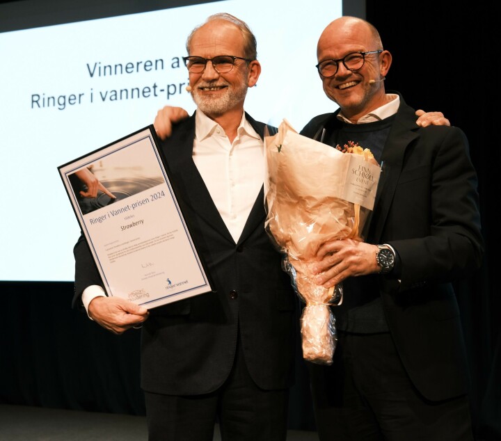 INKLUDERINGSHEDER: Administrerende direktør Torgeir Silseth (til venstre) mottok Ringer i vannet-prisen fra NHO-sjef Ole Erik Almlid. De to smilende sammen på scenen med blomster og pris.