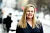Linda Stubsjøen står utendørs i en bygate med snø og uskarp trafikk i bakgrunnen.