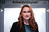 Ingvill Kvernmo står foran Arbeidstilsynets skilt i Oslo.