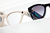 Nærbilde av lyse og svarte Ray-Ban Meta-briller på en hvit butikkhylle.