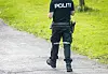 Politibetjent sett bakfra på en asfaltert gangvei mellom grønne gressflater.