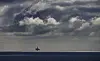 Kvitebjørn-plattformen skimtes på havhorisonten under mørke, dramatiske skyer.