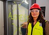 Person i verneutstyr foran en glassvegg merket «ASBEST».