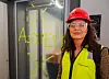 Person i verneutstyr foran en glassvegg merket «ASBEST».