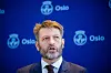 Eirik Lae Solberg taler foran en blå bakvegg med Oslo-logoer.