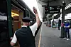 Overkonduktør gir klarsignal ved et tog på Oslo stasjon før avgang til Malmö.