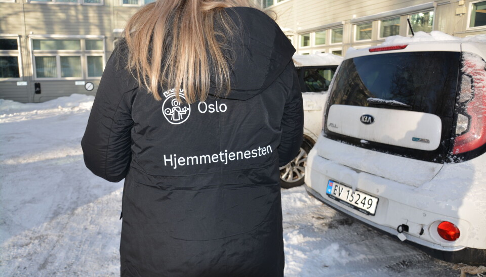 Vinterparkasene gjør det lett å gjenkjenne helsearbeiderne fra hjemmetjenesten. Kvinne med ryggen til iført parkasen. Ryggen er dekorert med Oslos byvåpen og «Hjemmetjenesten»