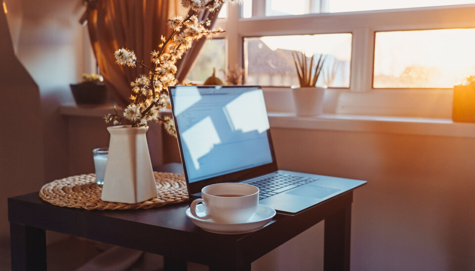 Bilde av PC på et bord med kaffekopp, i hjemmemiljø.