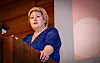 Erna Solberg på en talerstol.