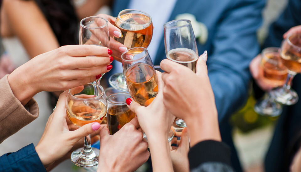Nærbilde av en gruppe festkledde mennesker som skåler med champagne.