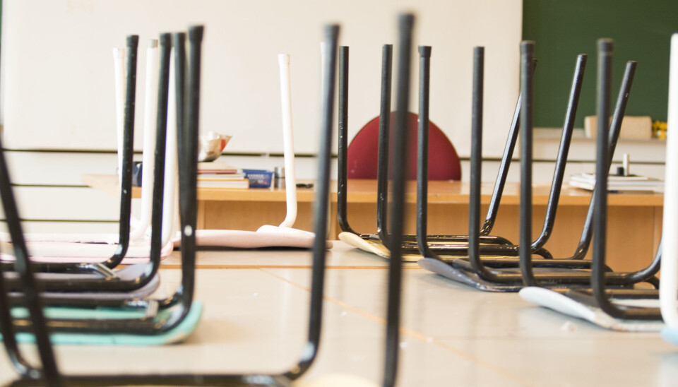 ET ARBEIDSMILJØPROBLEM: Å bli utsatt for vold og trusler er et arbeidsmiljøproblem, ikke et individuelt problem, understreker Ida Aagaard i Arbeidstilsynet. Bilde av stoler som er stablet på pultene i et tomt klasserom.