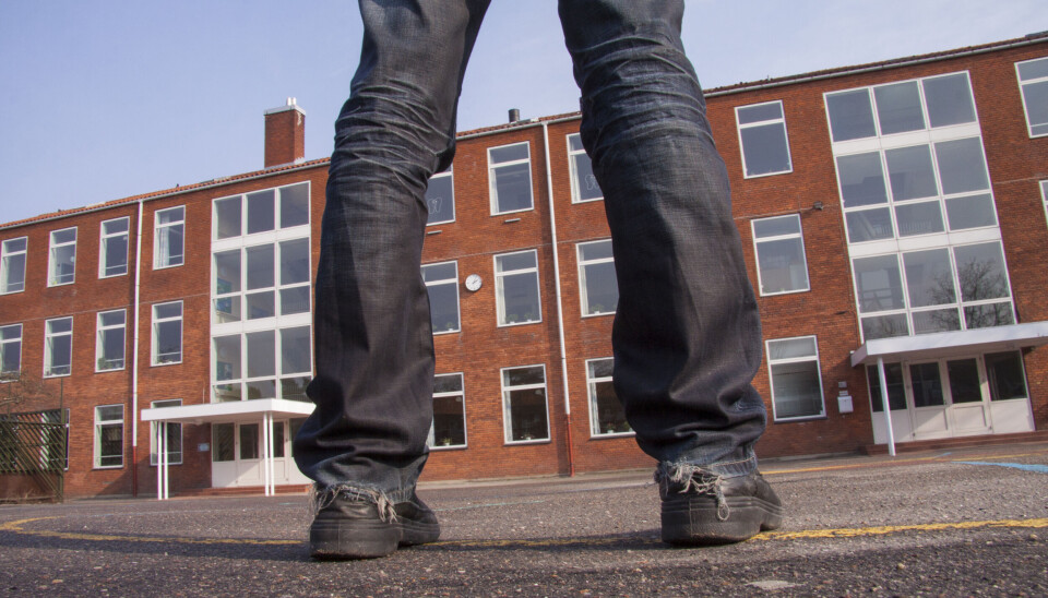 Bena til en ungdsomsskoleelev i skolegården utenfor en skolebygning.